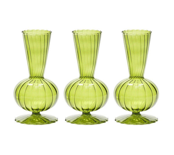 The Kim Seybert Tess Bud Vase Set of 3 in Olive features identical green glass vases with bulbous bases, narrow necks, flared openings, and elegant vertical stripes, arranged in a row against a white background.