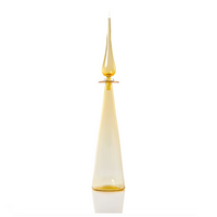 The Cariati Petite Decanter Straight Cone features a tall, elegant, handblown translucent yellow glass with a narrow neck, teardrop stopper, and flared base—modern barware sophistication set against a white background.