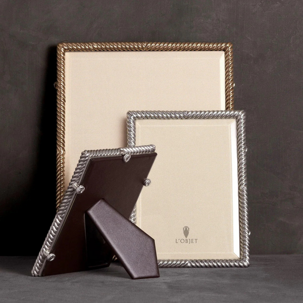 Two elegant L'Objet Deco Twist Platinum Frames with rope-like metallic borders are displayed against a dark background, with one positioned at the back and the other in front and slightly to the side.