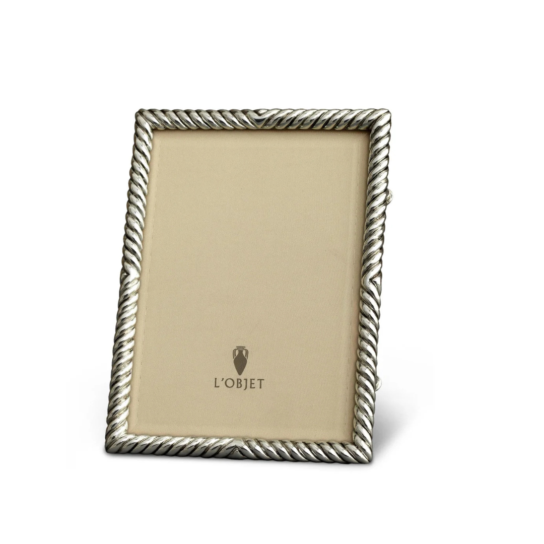 The L'Objet Deco Twist Platinum Frame is a silver handcrafted piece with a twisted rope design and features an upright display with a beige insert showing the L'Objet logo at the center.