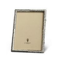 The L'Objet Deco Twist Platinum Frame is a handcrafted rectangular silver picture frame, featuring a twisted rope design, a beige logo insert at the center, and stands upright at a slight angle.