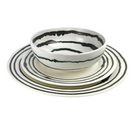The Linea Dinnerware by Michael Wainwright includes a bowl, salad plate, and dinner plate, each featuring black wavy concentric rings on a white background.
