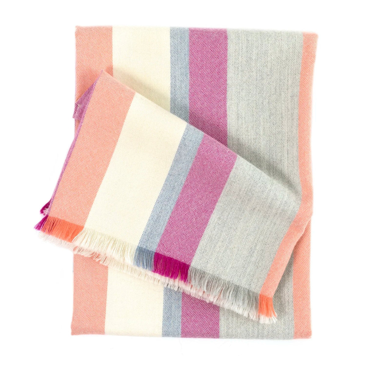 The Bolsa Throw by Dove & Donkey is a folded baby alpaca blanket with vertical stripes in pastel pink, peach, cream, lavender, and gray. Lightweight and soft with fringed edges, it adds a modern plaid accent to your home.