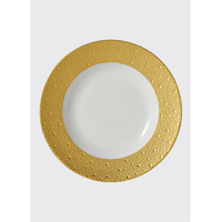 The Bernardaud Ecume Dinnerware Gold shows a white ceramic plate with a broad, textured gold rim, displayed against a plain light gray background.