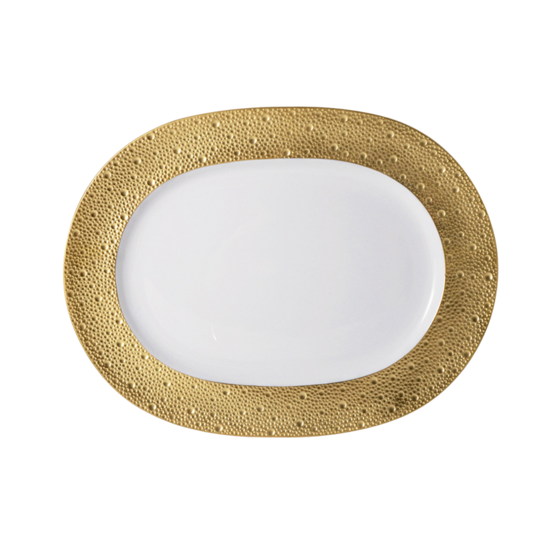 The Bernardaud Ecume Dinnerware Gold plate, crafted from Limoges porcelain, features an oval shape and a wide textured gold border, shown from above on a plain white background.