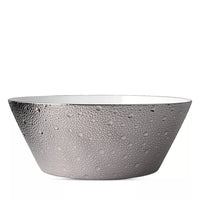 The Ecume Platinum Dinnerware by Bernardaud features a wide, round bowl with a white interior and textured metallic silver exterior with raised dots, offering a modern, elegant look for contemporary table settings.