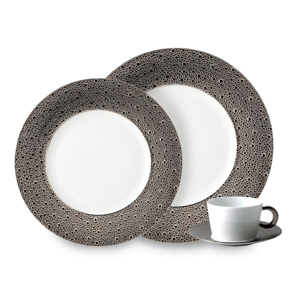 The Ecume Platinum Dinnerware by Bernardaud is a three-piece set from Limoges, France, featuring a dinner plate, salad plate with wide textured rims and dots, plus a white cup and saucer with a dark handle—ideal for contemporary tables.
