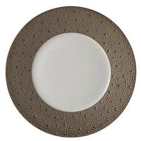The Bernardaud Ecume Platinum Dinnerware features a round plate with a white center and a wide, textured metallic bronze rim adorned with small raised dots, perfect for modern table settings.