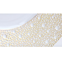 Close-up of a Bernardaud Ecume Dinnerware Mordore plate, showcasing a white surface with an elegant gold and white circular dot pattern along the rim.