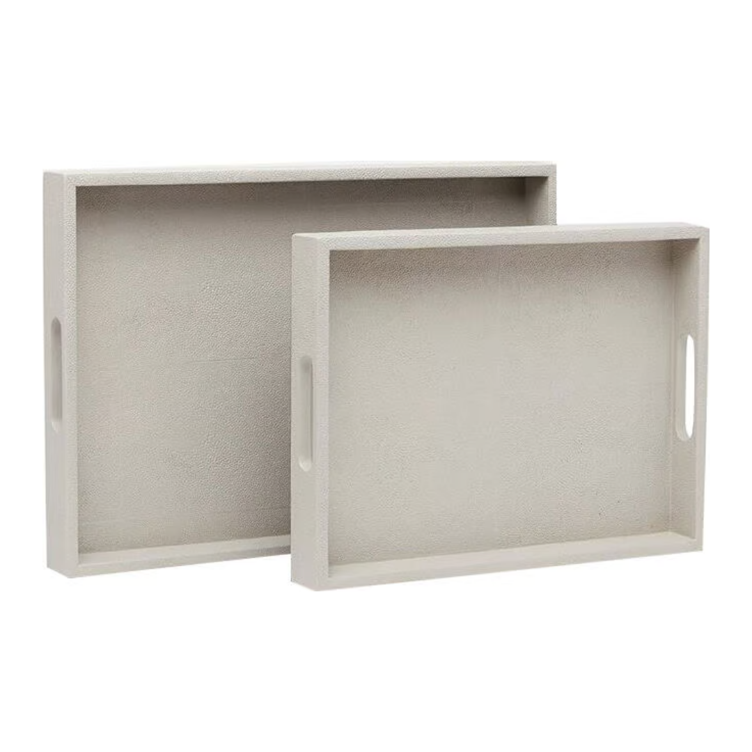 Two rectangular light grey faux shagreen Emery Tray Rectangle French Grey decorative trays with cutout side handles, nested one behind the other.