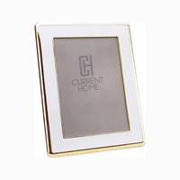 The Addison Ross Enamel Wide Gold & White Frame stands upright, its gold-trimmed border adding sophistication and elegance to any space, while offering a stylish blank canvas for your favorite photo.