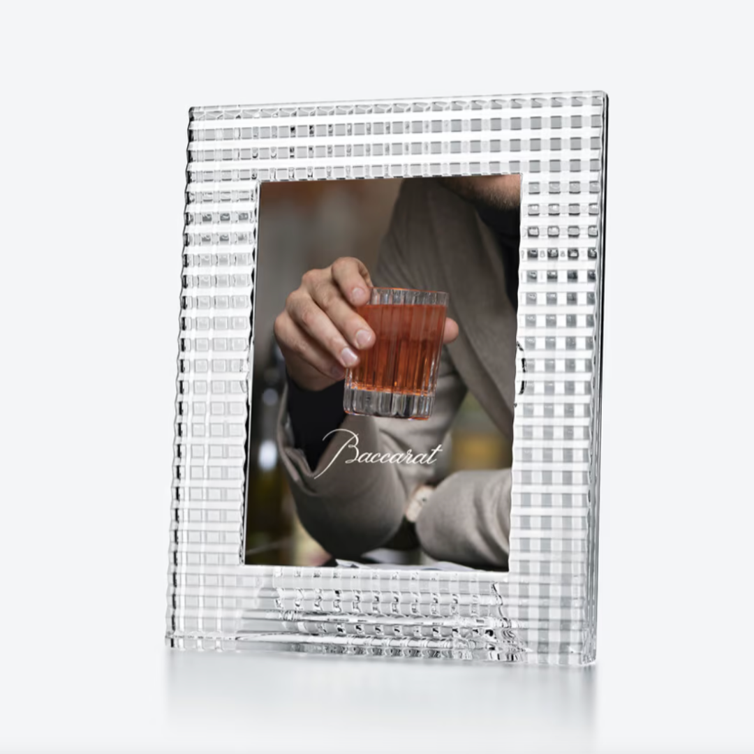 The Baccarat Eye Photo Frame, a square and textured design, showcases a photo of someone holding a glass of amber liquid with the word "Baccarat" visible on the image.