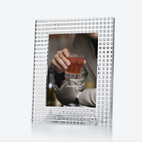 The Baccarat Eye Photo Frame, a square and textured design, showcases a photo of someone holding a glass of amber liquid with the word "Baccarat" visible on the image.