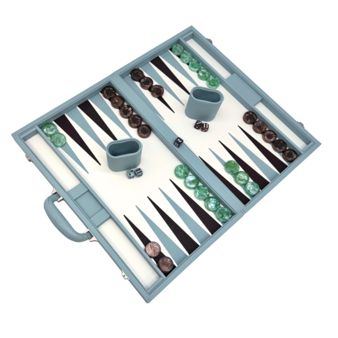 The Tizo Viceroy Backgammon - Light Blue set features green and brown checkers, two dice cups, and dice. Its light blue faux leather board has a handle with pieces set on a white and dark brown playing surface.