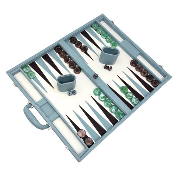 The Tizo Viceroy Backgammon - Light Blue set features green and brown checkers, two dice cups, and dice. Its light blue faux leather board has a handle with pieces set on a white and dark brown playing surface.