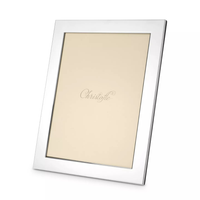 The Fidelio Christofle Silver Plated Frame 7x9.5 by Christofle is a sleek, rectangular silvered photo frame featuring a beige placeholder inscribed with "Christofle" in elegant script at the center, shown photographed at an angle.