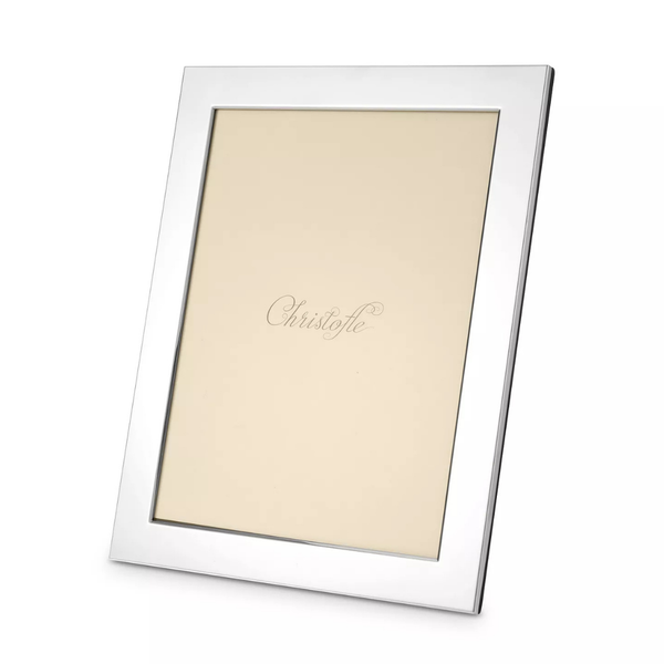 The Fidelio Christofle Silver Plated Frame 7x9.5 by Christofle is a sleek, rectangular silvered photo frame featuring a beige placeholder inscribed with "Christofle" in elegant script at the center, shown photographed at an angle.