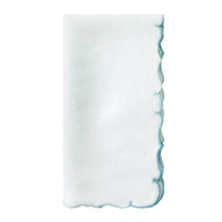 A crisp white linen napkin with scalloped edges and delicate ice blue embroidery from the Bodrum Firenze Napkin Set of 4.