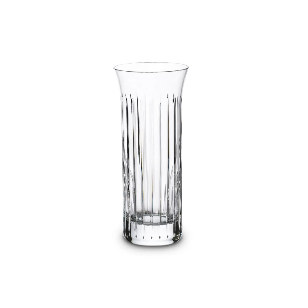 The Baccarat Flora Vase, a clear and tall piece with vertical grooves, sits on a white background, highlighting its quality craftsmanship and making it a sophisticated addition to any home décor.