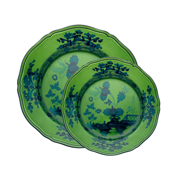 Two green Oriente Italiano Dinnerware Malachite plates by Ginori 1735, one slightly smaller and overlapping the other, feature scalloped edges and dark blue floral patterns, capturing the elegance of Italian tableware design.