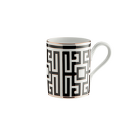 The Ginori 1735 Labirinto Dinnerware Nero mug features a black Greek key pattern and gold accents on white ceramic, displaying striking geometric decoration against a white background.