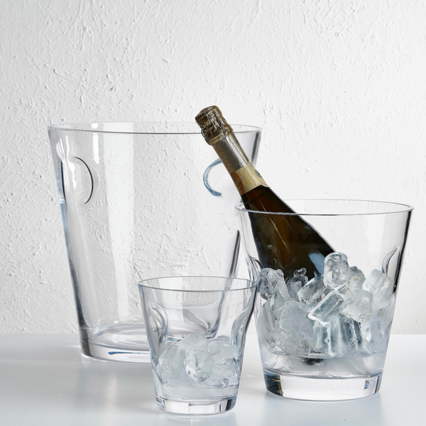 The Glacier Cooler by Nude Glassware features three lead-free crystal containers—a tall ice bucket, a glass holding a champagne bottle on ice, and a small glass with ice cubes—set against a white background for modern barware style.