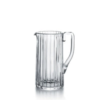 The Baccarat Harmonie Pitcher features vertical grooves, a handle, and a pouring spout, displayed against a plain white background.