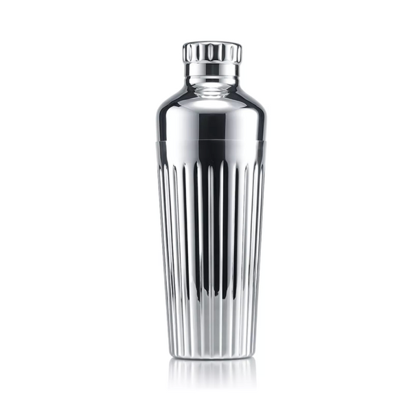 A gleaming Baccarat Harmonie Shaker with vertical grooves stands upright against a white background, highlighting its elegant stainless steel design.