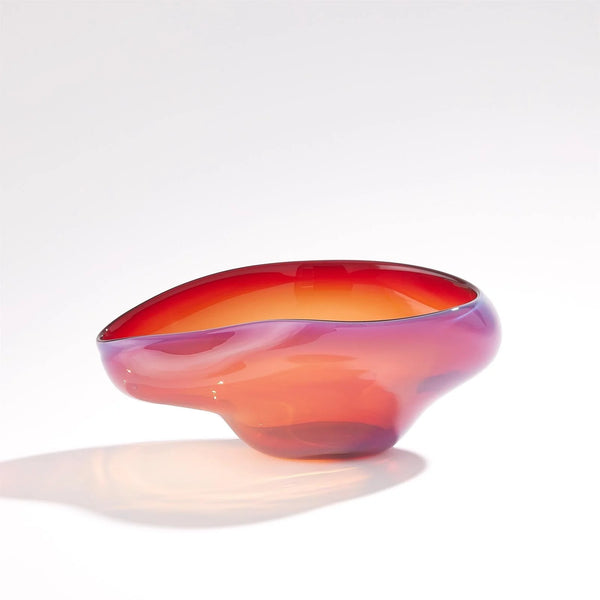 The Harmony Bowl Red - Small by Global Views / Surya is a glossy, abstract handblown art glass piece featuring a flowing, asymmetric shape and gradient colors that blend from orange to red. Set against a plain white background, this handmade bowl exudes individuality and elegance—perfect for modern luxury décor.