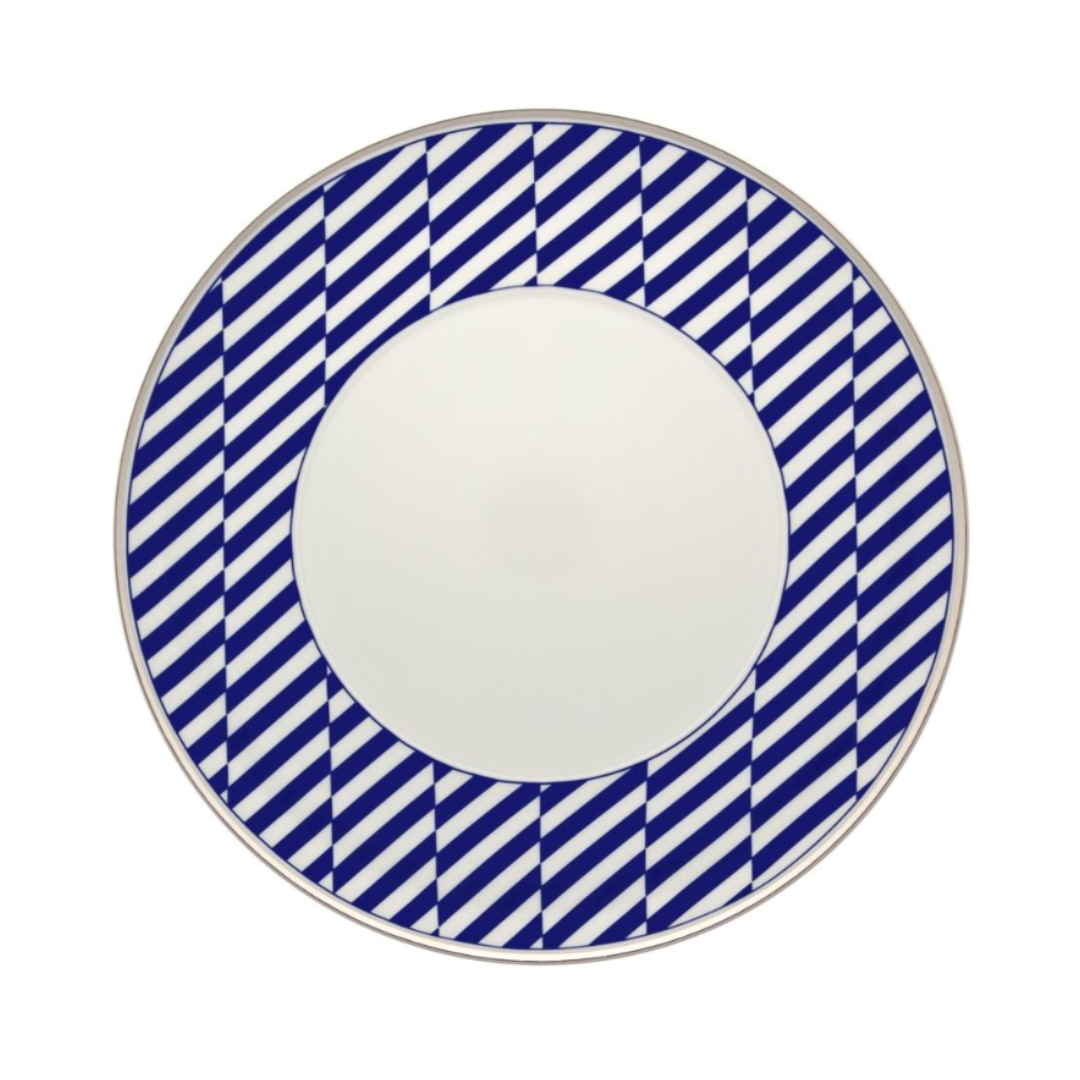 The Vista Alegre Harvard Dinnerware is a round white porcelain plate with a wide rim featuring bold blue and white diagonal stripes, evoking classic New England style. Made in Portugal.