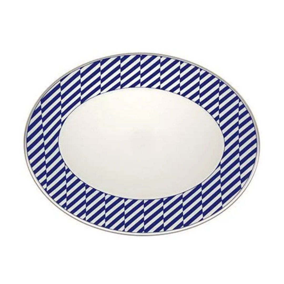 The Harvard Dinnerware oval plate by Vista Alegre features a white center, blue and white diagonal striped border, and silver rim, adding New England-inspired elegance to any table setting. Crafted from fine porcelain.