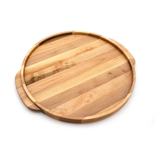 The Elmore Round Serving Board by JK Adams features light and medium-toned wood strips, a slightly raised edge, and two small handles on opposite sides. Shown here on a white background.