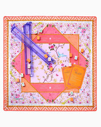 The Oh My Mahjong Mahjong Mats feature a floral, geometric-patterned non-slip surface with purple racks, orange cards, and small tiles spread across a pink and orange neoprene mat.