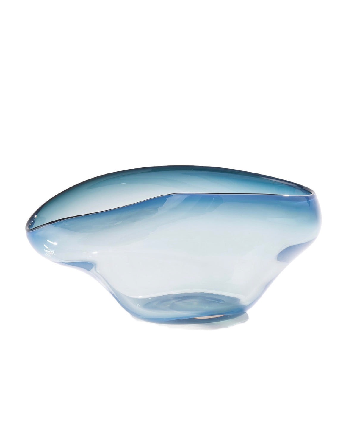 Introducing the Harmony Bowl Dark Blue by Global Views / Surya—a translucent blue glass bowl with smooth, flowing curves and an asymmetrical, uneven rim. Its subtle ombré design creates a unique and striking serving option, especially against a white background.