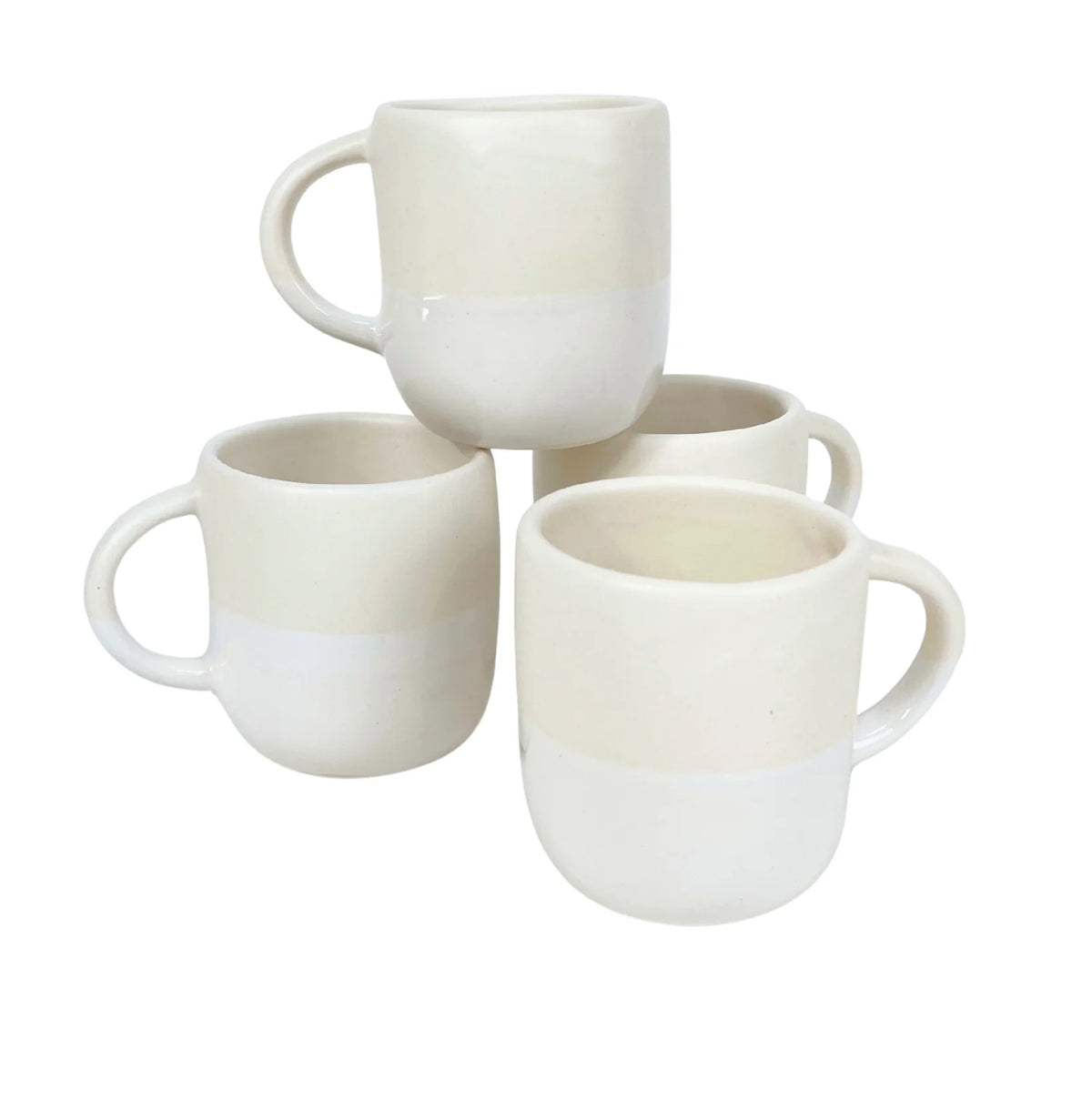 Four white Urban Dinnerware ceramic mugs by Alex Marshall Studios, featuring rounded shapes and handles, are stacked in pairs. Their smooth finish complements handmade stoneware plates. These mugs are microwave and dishwasher safe.
