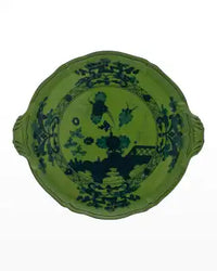 The Oriente Italiano Dinnerware Malachite by Ginori 1735 is a green porcelain plate with two small handles, adorned with dark blue floral and landscape motifs in the center and around the rim—a refined Italian tableware piece.