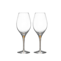 Two Orrefors Intermezzo Balance Wine Glasses Gold, set of 2, stand upright with long stems side by side on a plain white background.