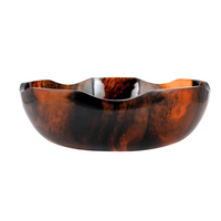 Introducing the Nashi Home Tortoise Jacqui Bowl: a wavy-edged, semi-translucent serving piece featuring a glossy tortoiseshell pattern in warm tones of brown, amber, and black against a crisp white background—an elegant addition that elevates any home decor.
