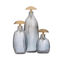 The Karis Decanter by Arteriors features optic glass with vertical ridges and a unique flat, semi-circular antique brass stopper—a stylish accent for your bar cart.