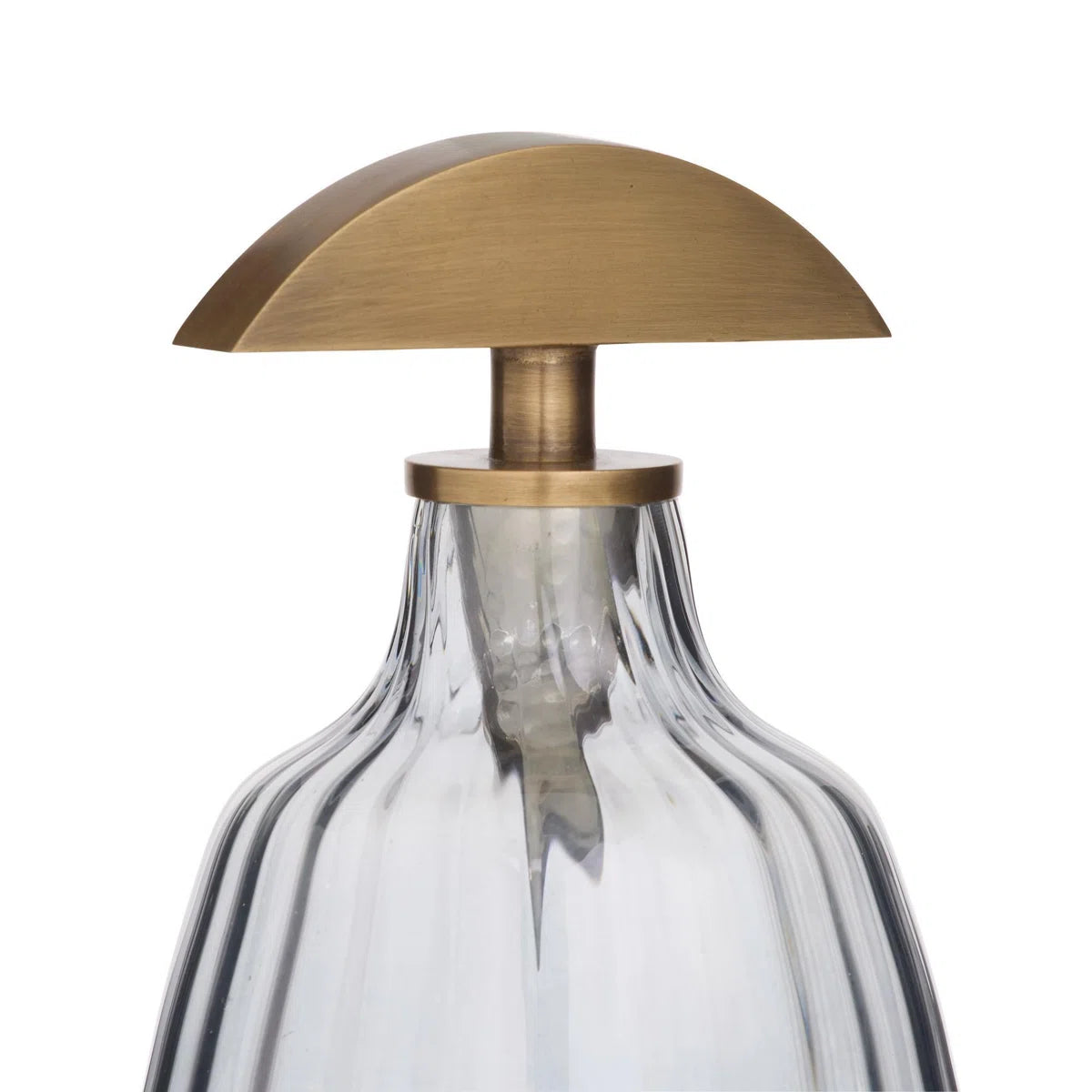 The Karis Decanter by Arteriors features clear optic glass with vertical ridges, finished with a flat semicircular antique brass stopper and a matching brass neck collar.