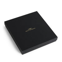 A square black gift box featuring the gold-stamped text L’OBJET JESSICA MCCORMACK on the lid, housing a Jessica McCormack Shell Flatware 5 pc Set - Gold.