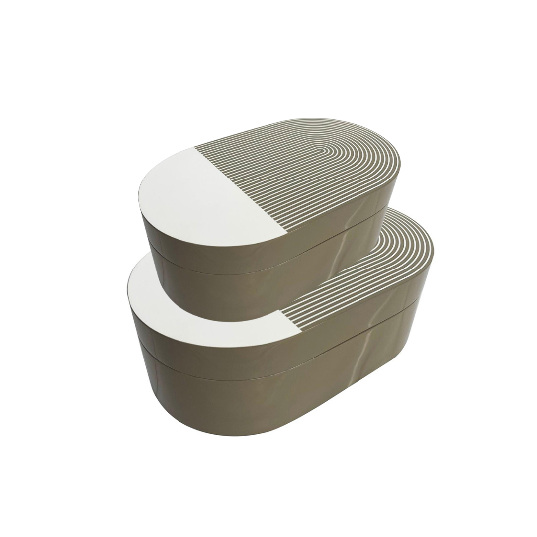 The Lacquer Stripe Box Grey by Von Gern Home features stacked, oval shapes with beige sides and white lids accented by gray concentric ovals—perfect for storing jewelry and enhancing any modern, minimalist decor.