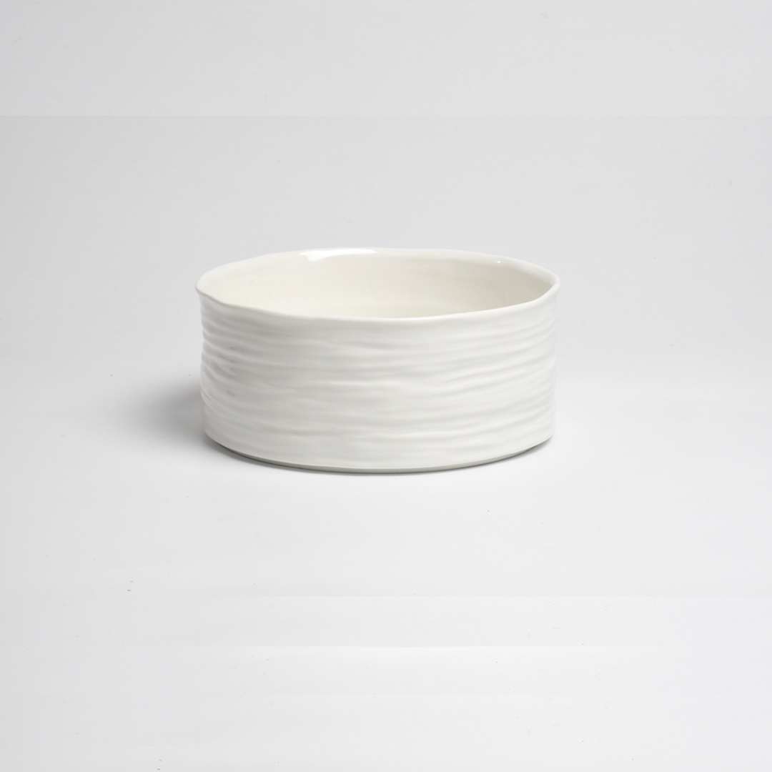 The PAMPA BAY Le Blanc Bowl is a plain white porcelain bowl with a subtly wavy textured surface, shown against a simple white background.