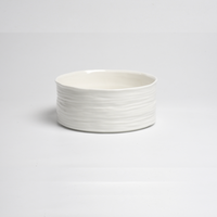 The PAMPA BAY Le Blanc Bowl is a plain white porcelain bowl with a subtly wavy textured surface, shown against a simple white background.