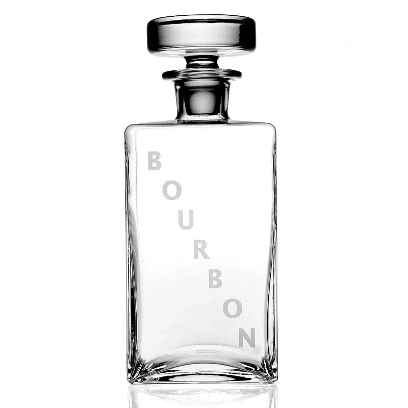 The William Yeoward Lillian Decanter Bourbon is a clear, rectangular crystal glass decanter with a round stopper and "BOURBON" in large vertical letters on the front, shown empty against a white background.