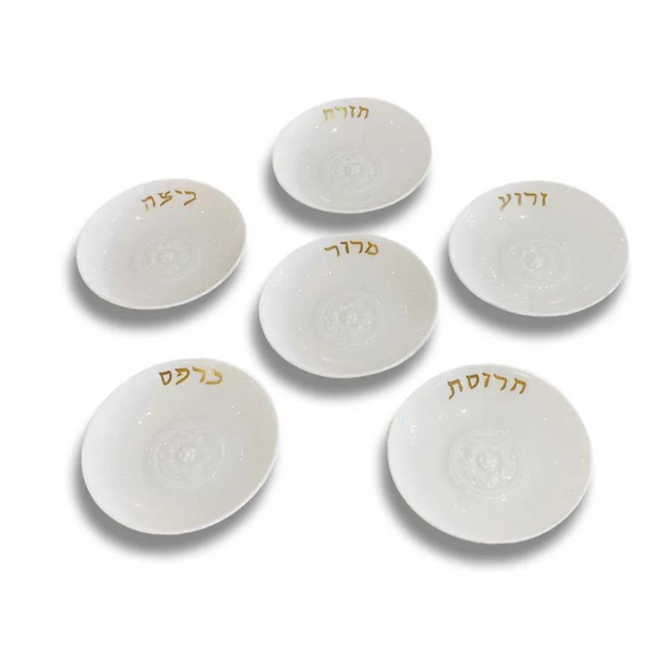 The Bernardaud Louvre Seder Dishes Set of 6 features elegant white plates arranged in a circle, each with a unique Hebrew word in gold script. An ideal heritage gift for Passover Seder, displayed on a plain white background.