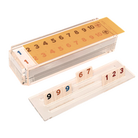 The Luxe Dominoes Rummy Acrylic Game Set features clear tile holders with numbered tiles (9, 9, 6, 7 on one; 1, 2, 3 on another) and a scoring board from 1 to 10—perfect as a thoughtful Rummikub gift.