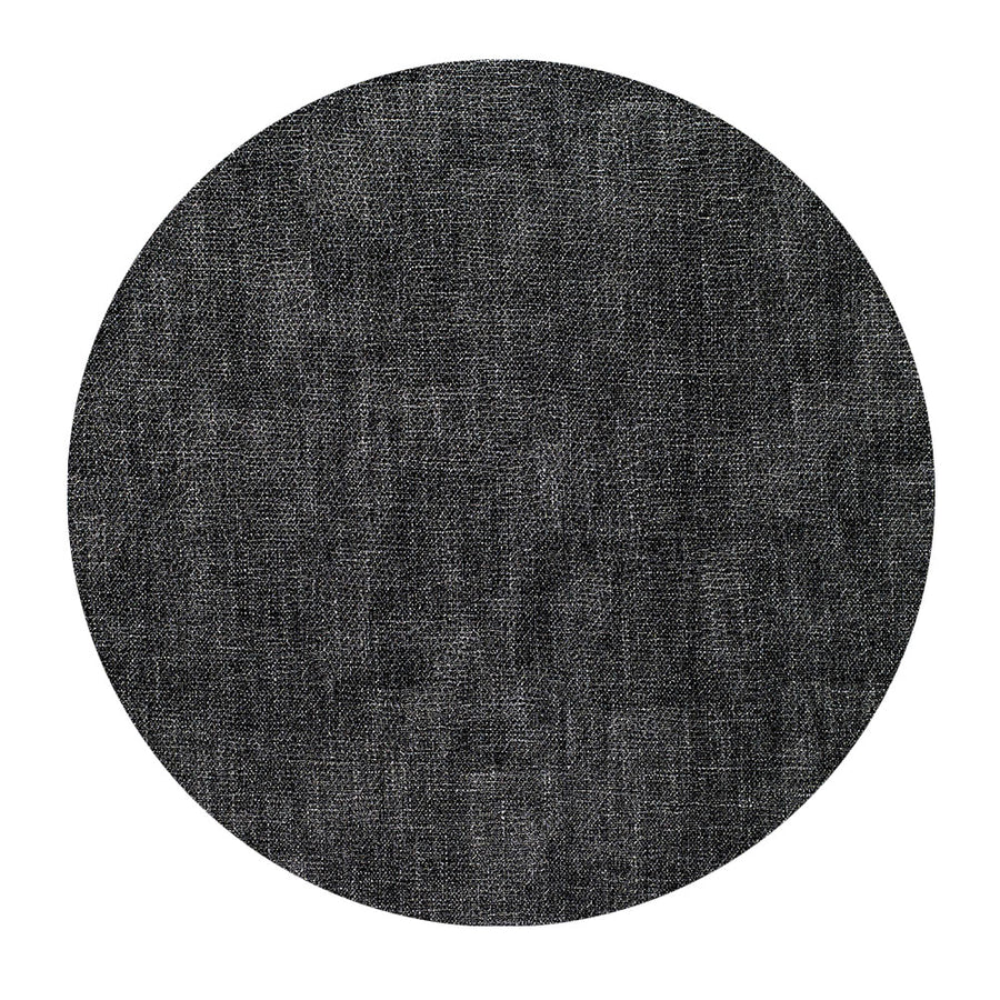 A round, dark gray textured fabric swatch, shown on a white background, represents the Bodrum New Luster Round Placemat Smoke Set of 4 (DD), featuring elegant woven fabric with subtle shading variations and a mottled appearance.