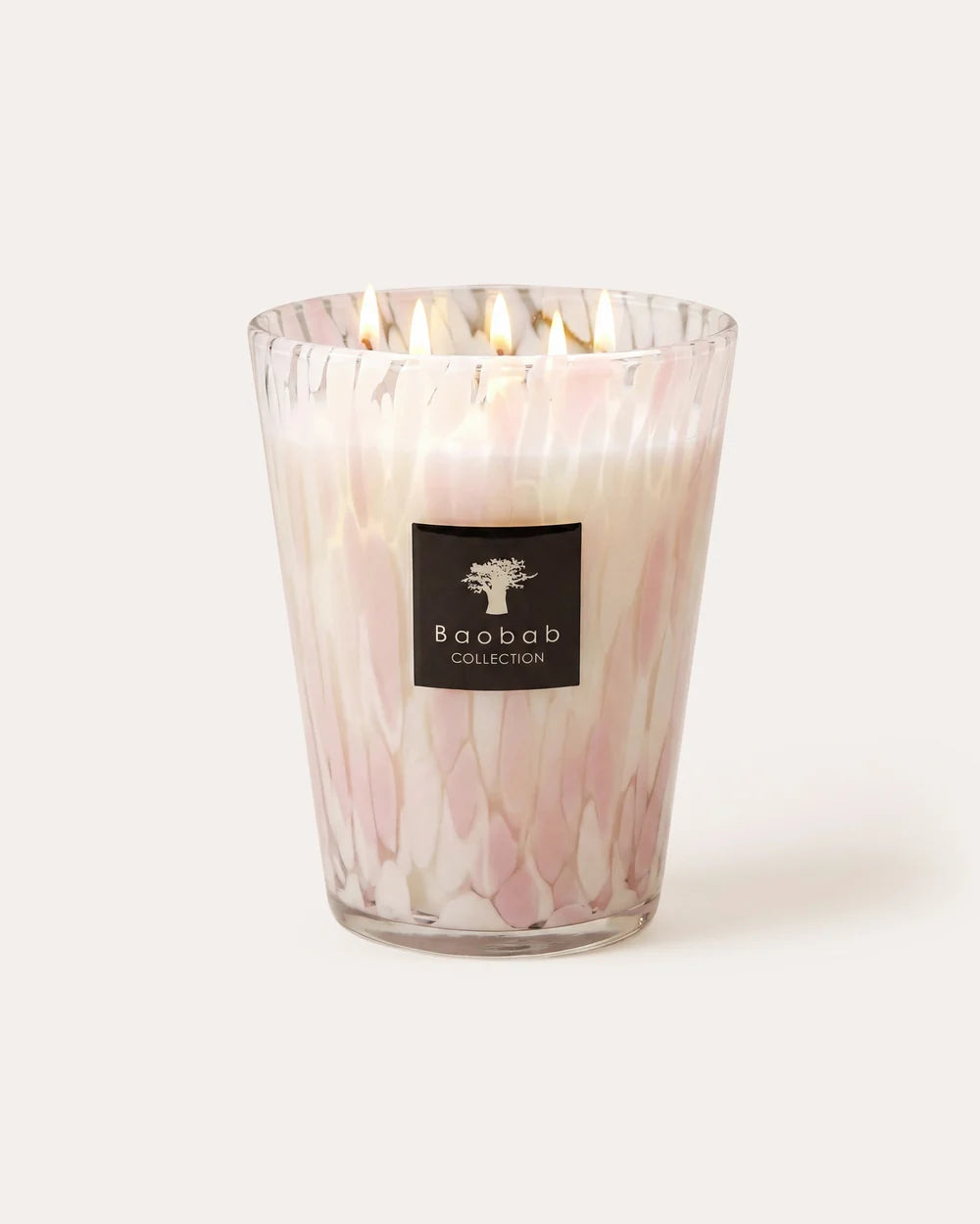 A four-wick Baobab Pearls Candle - White in a clear glass vessel patterned with vertical pink and white streaks, featuring a square logo label on the front.