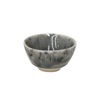 The Costa Nova Madeira Grey Dinnerware features a handcrafted small ceramic bowl with a gray and black marbled pattern, slightly flared rim, glossy finish, and short round foot, shown against a white background.